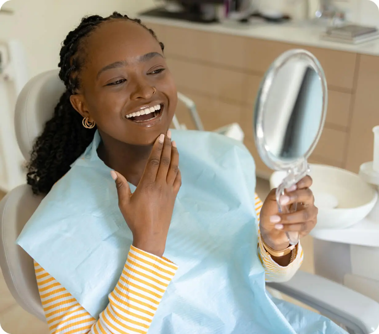Woman admiring teeth in dentist's office