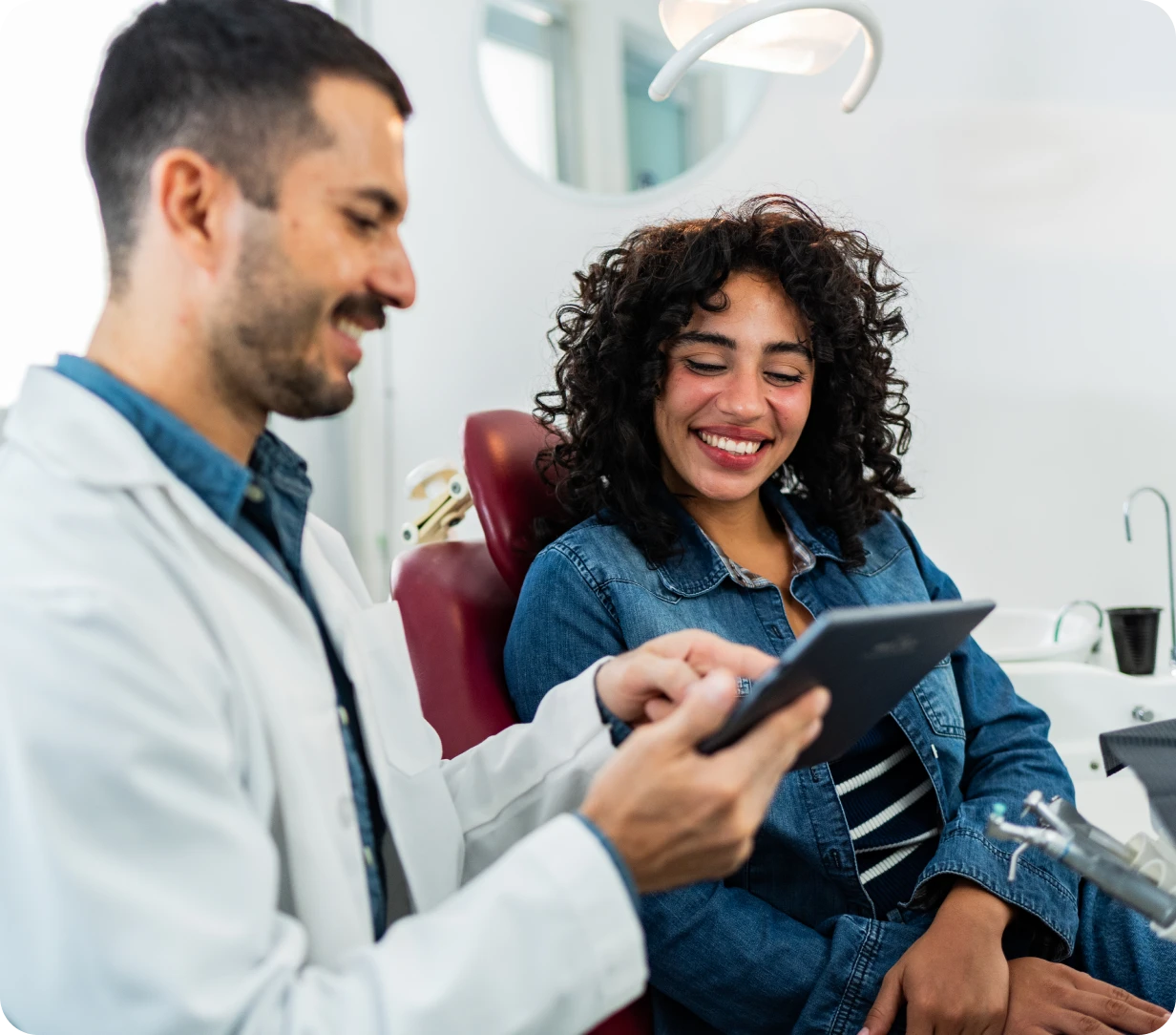 Dentist and patient smiling together